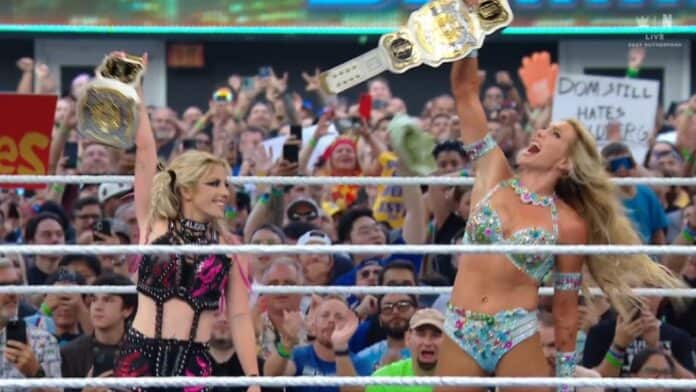 Two women in bikini's holding up their wwe championship belts.
